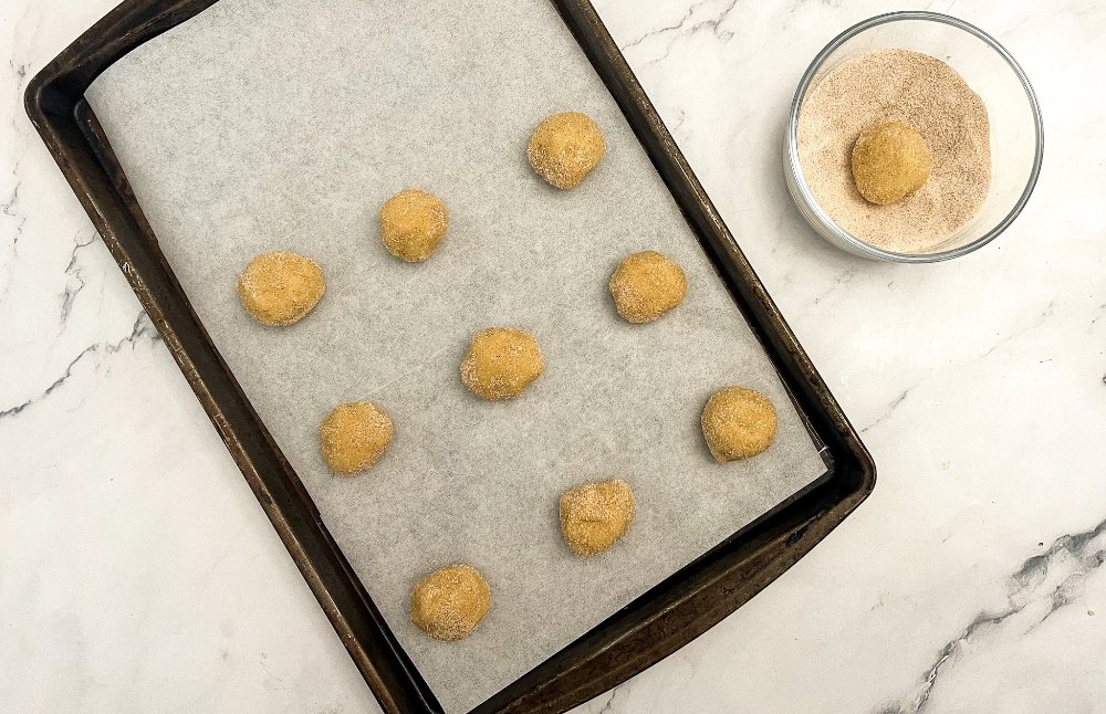 Rolling cookies in cinnamon sugar