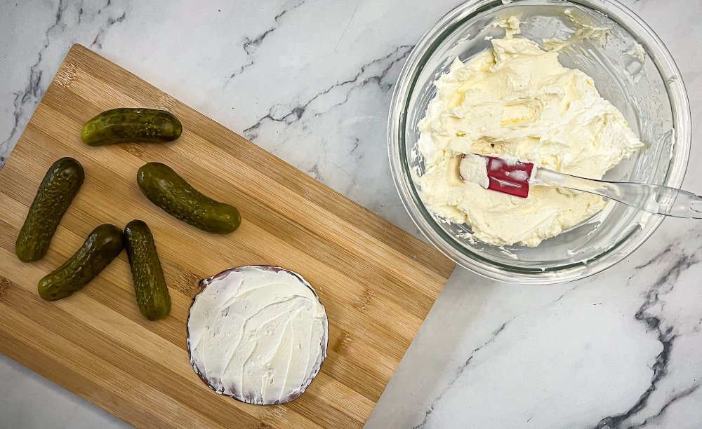 Spreading cream cheese on ham slices