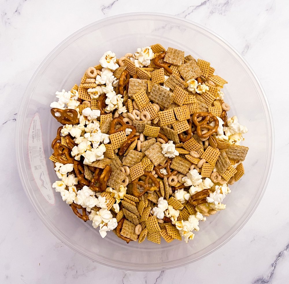 Cereal, popcorn, triscuits, and pretzels in a bowl