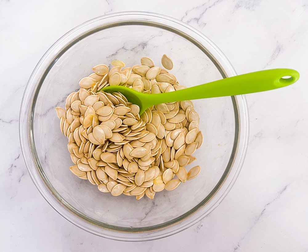 Mixing olive oil and pumpkin seeds