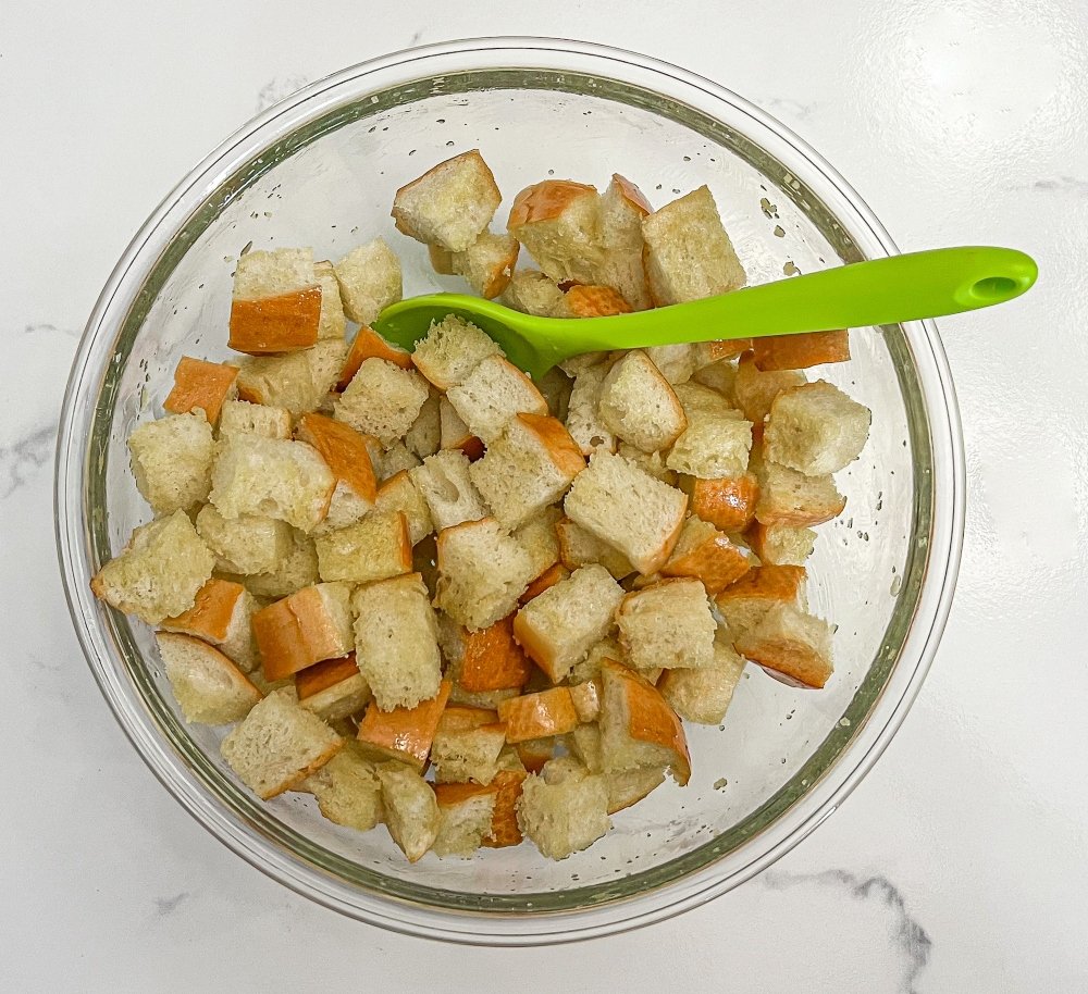 Mixing olive oil with bread cubes