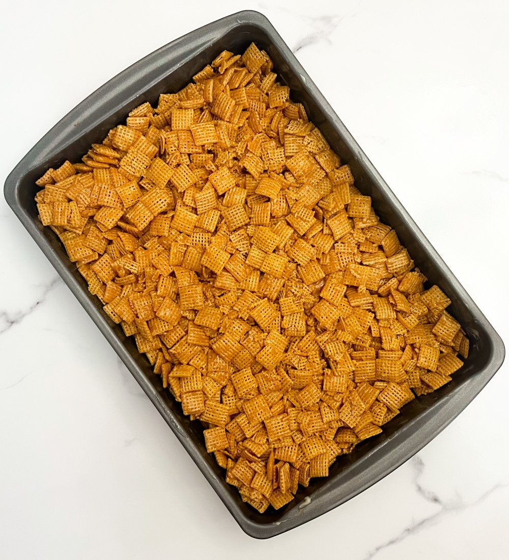 Pressing Chex cereal into baking pan