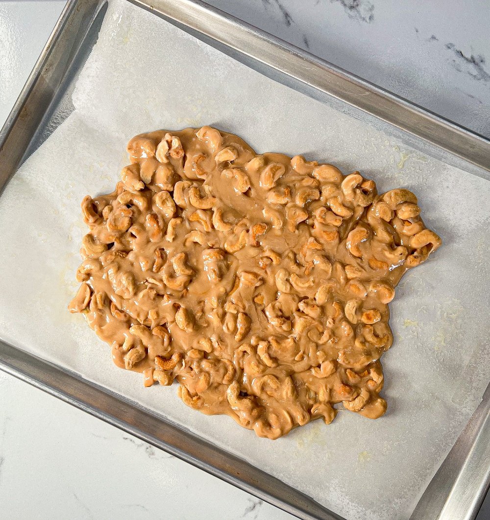 spreading cashew brittle on baking sheet