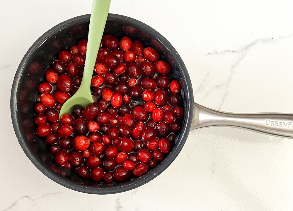 Stirring cranberries in sugar water